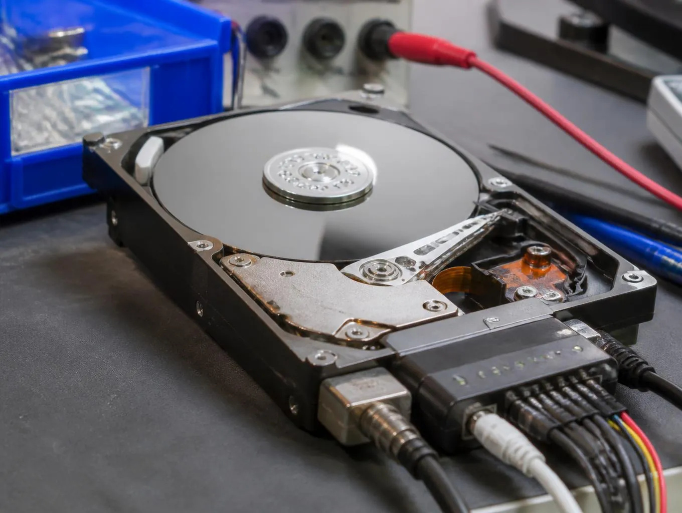 Disque dur ouvert en cours de récupération de données dans l'atelier ASD Electronique à Perpignan